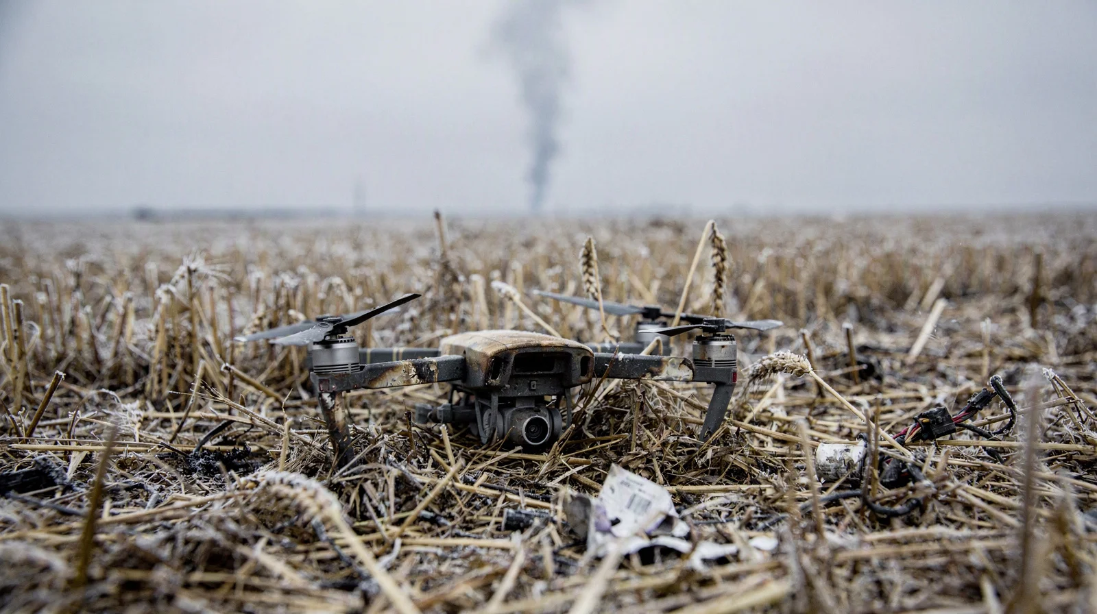 Field technicians repair a damaged ground robot at night beside stacked spare rotor crates