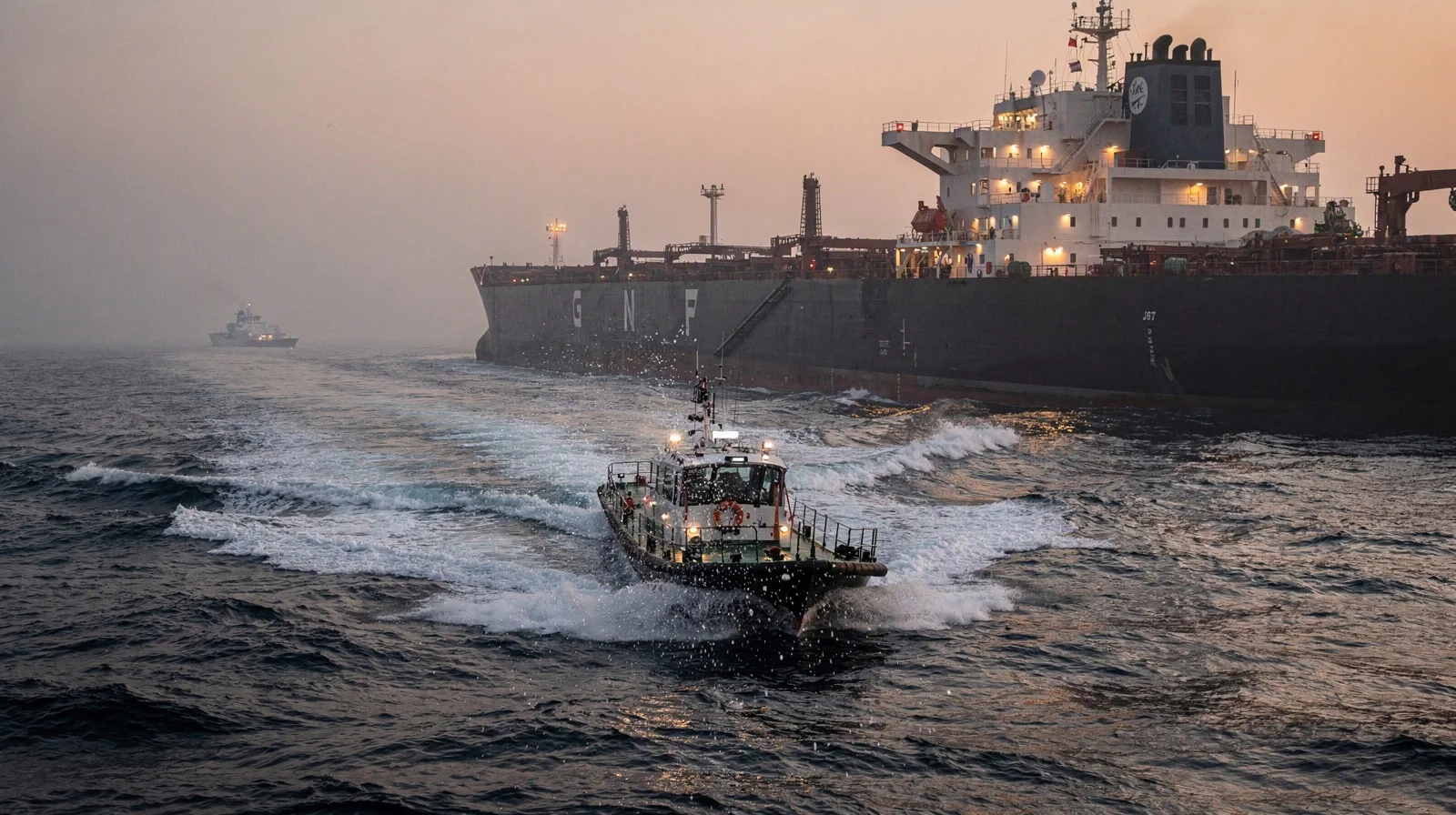 A harbor pilot boat crosses the wake of a crude tanker near the Strait of Hormuz at dawn, with a low patrol craft in the distance